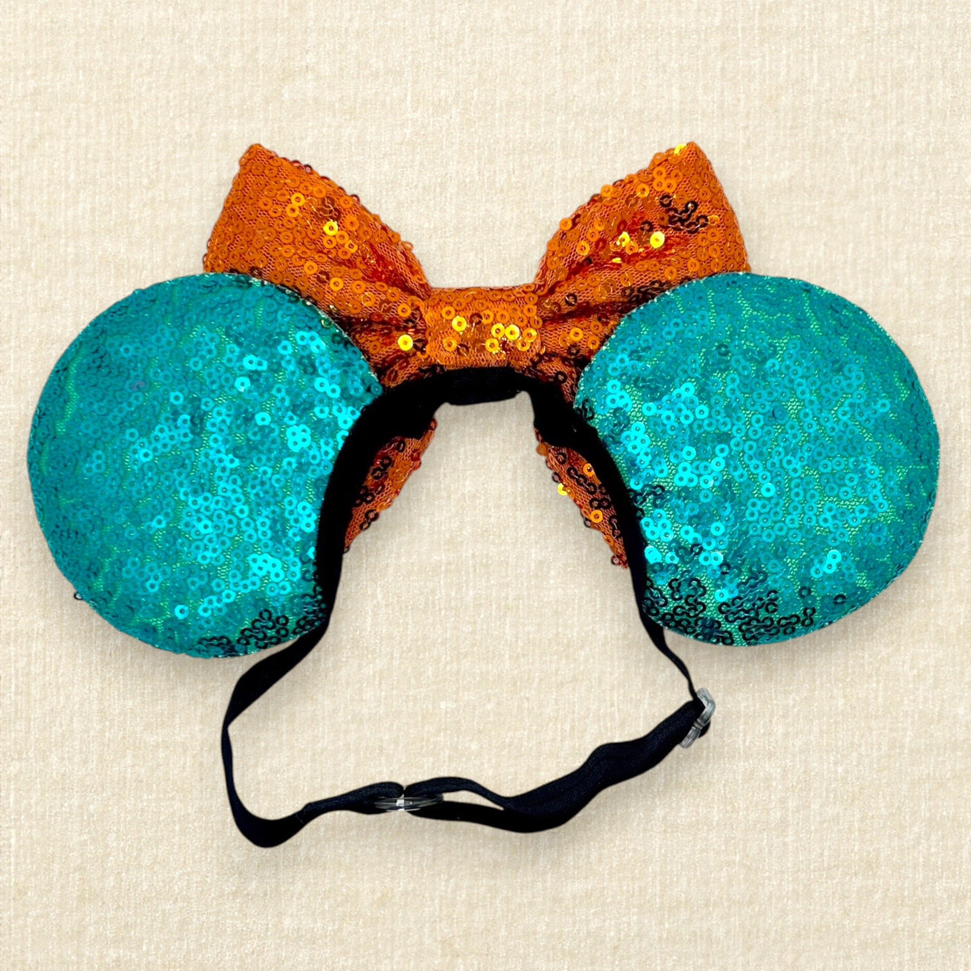 Halloween-themed teal mouse ears with black bats, orange bow, and large bat wings (back view)