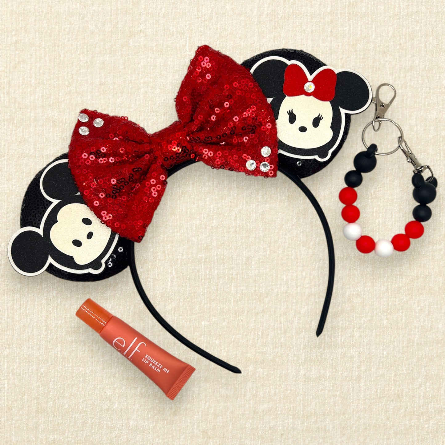 Black sequin mouse ears headband with red sequin bow and glitter mouse characters; pink lip balm; black and red beaded mouse ears holder clip