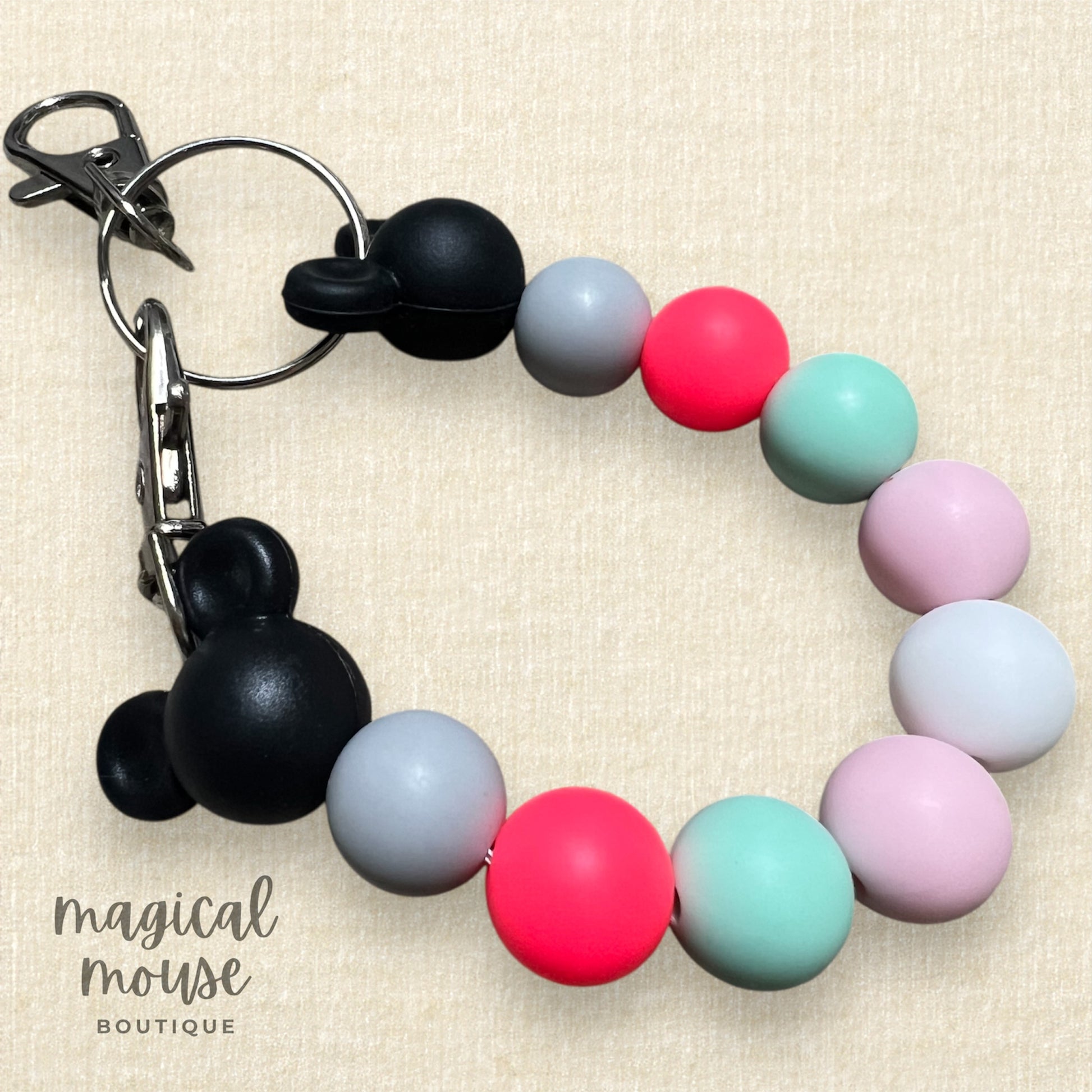 Colorful beaded keychain with black Mickey Mouse ears on a beige background
