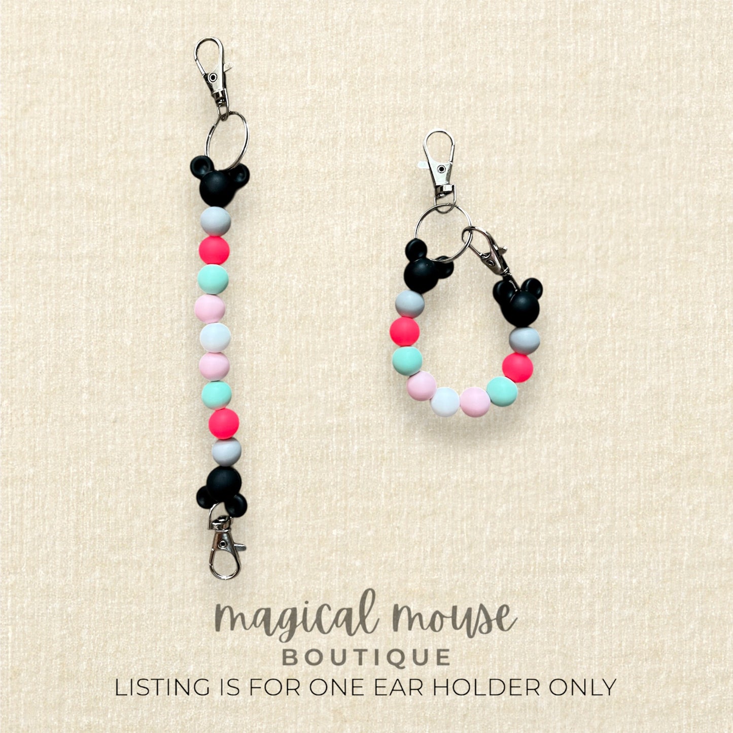 Colorful beaded ear holder with black mouse ears on a beige background, branded 'magical mouse boutique'.