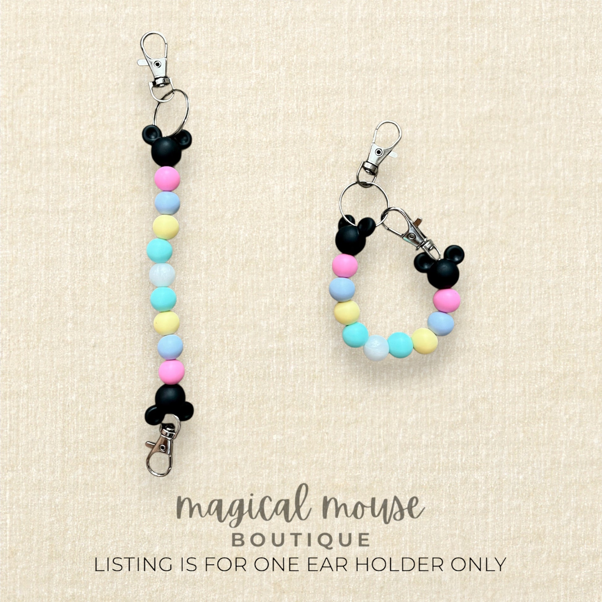 Two colorful Mickey Mouse ear keychains on a beige background with 'magical mouse boutique' text.