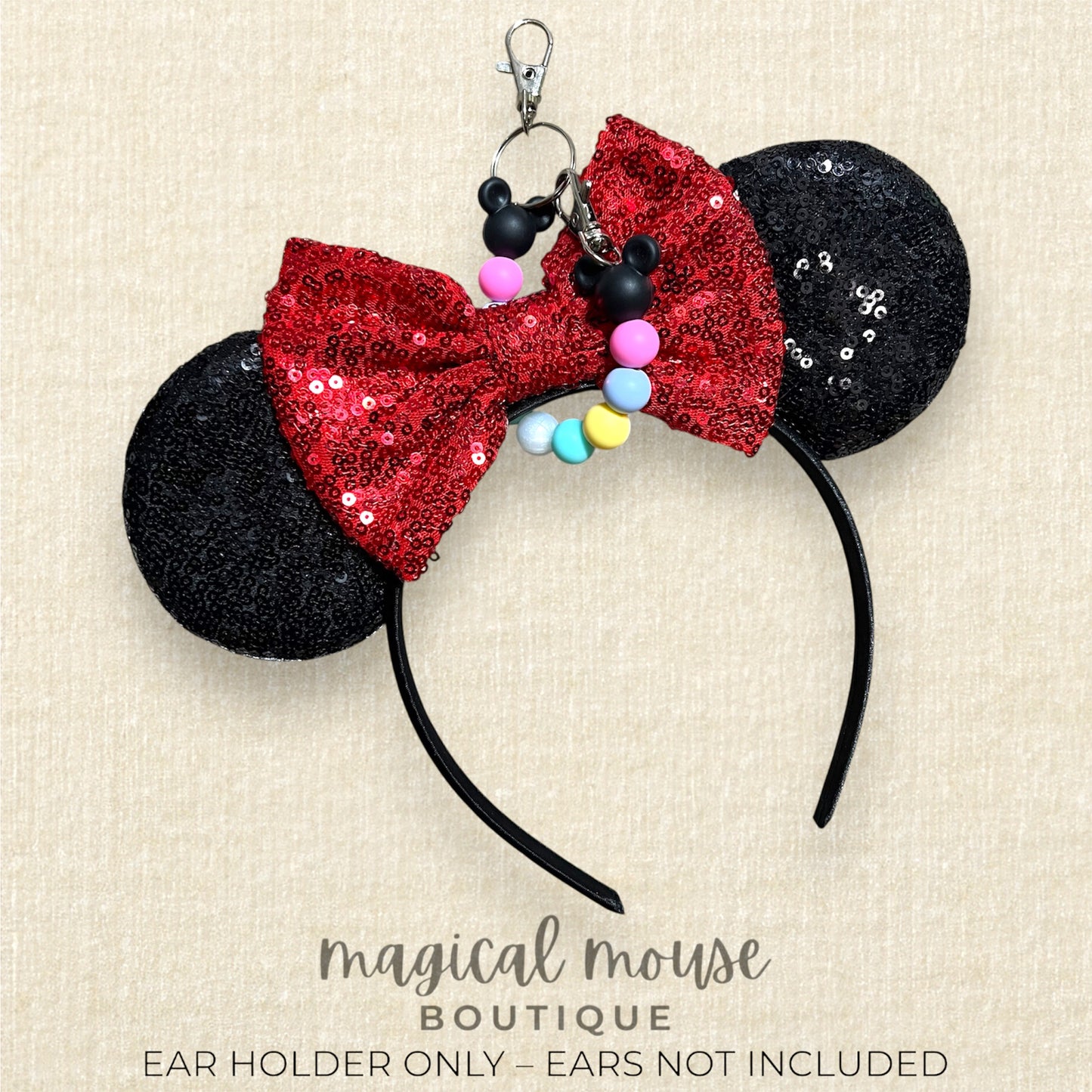 Black and red sequin mouse ears with colorful beaded ears holder on a beige background, labeled 'magical mouse boutique'.