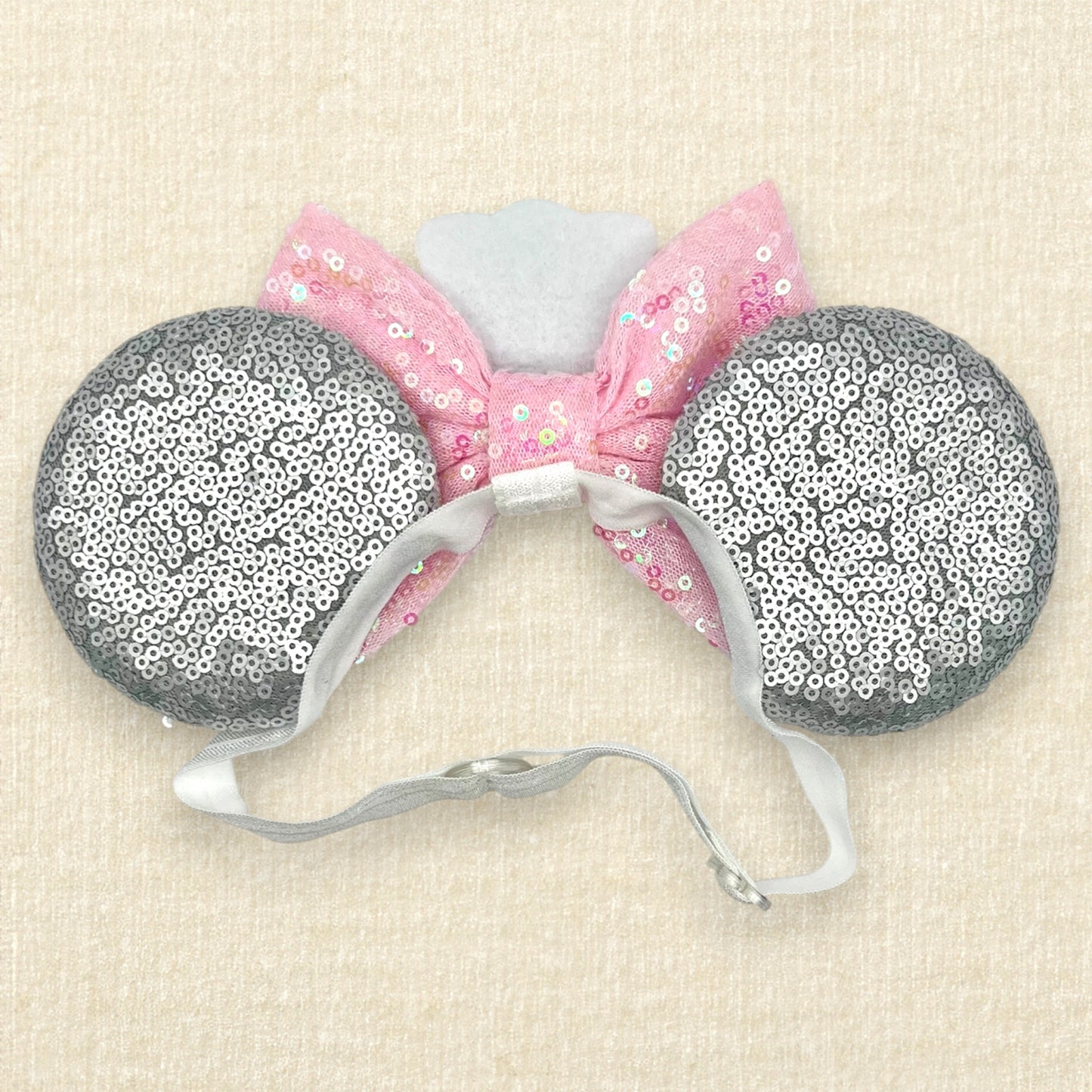 Silver mouse ears with pink sequin bow, mini white chef's hat, and pink glitter mouse nose with whiskers on an elastic headband (back view)