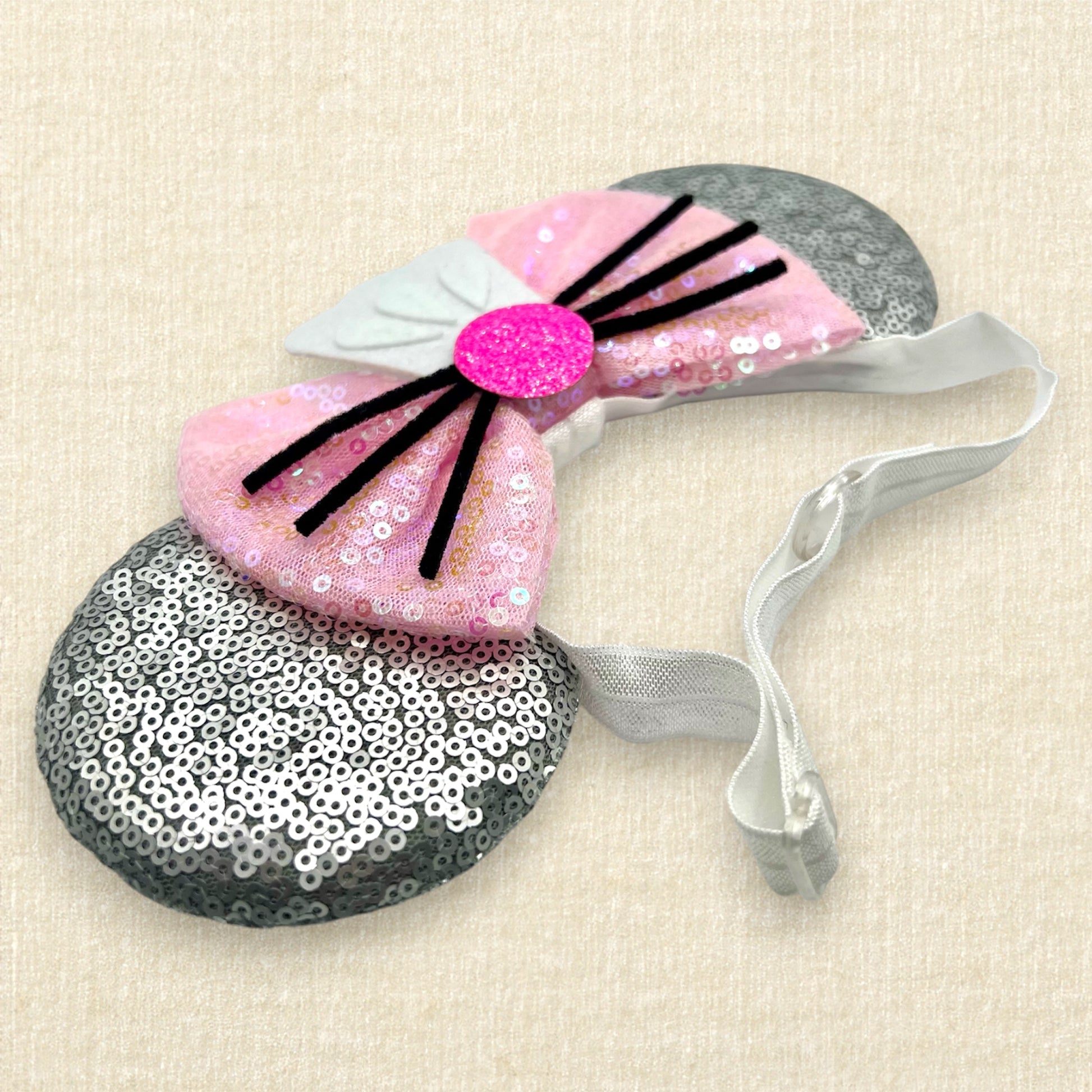 Silver mouse ears with pink sequin bow, mini white chef's hat, and pink glitter mouse nose with whiskers on an elastic headband