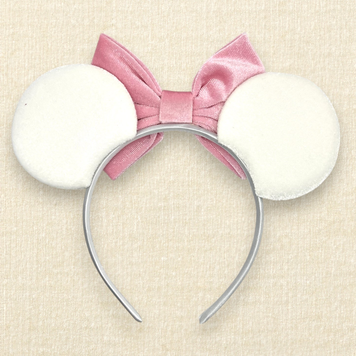 White velvet mouse ears with colorful Mickey pearls and pink velvet bow