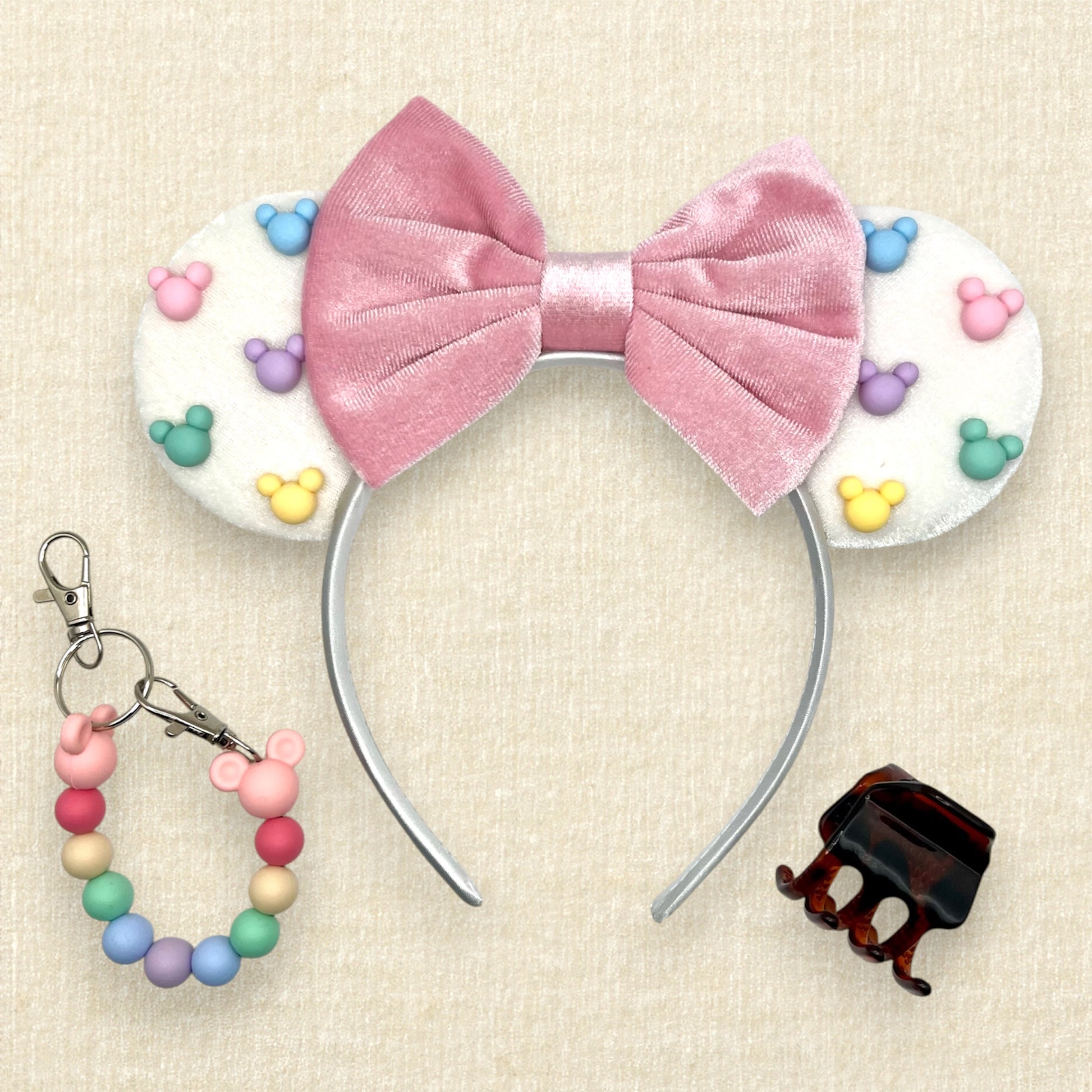 White velvet mouse ears with colorful Mickey pearls and pink velvet bow; colorful beaded mouse ears holder; claw clip