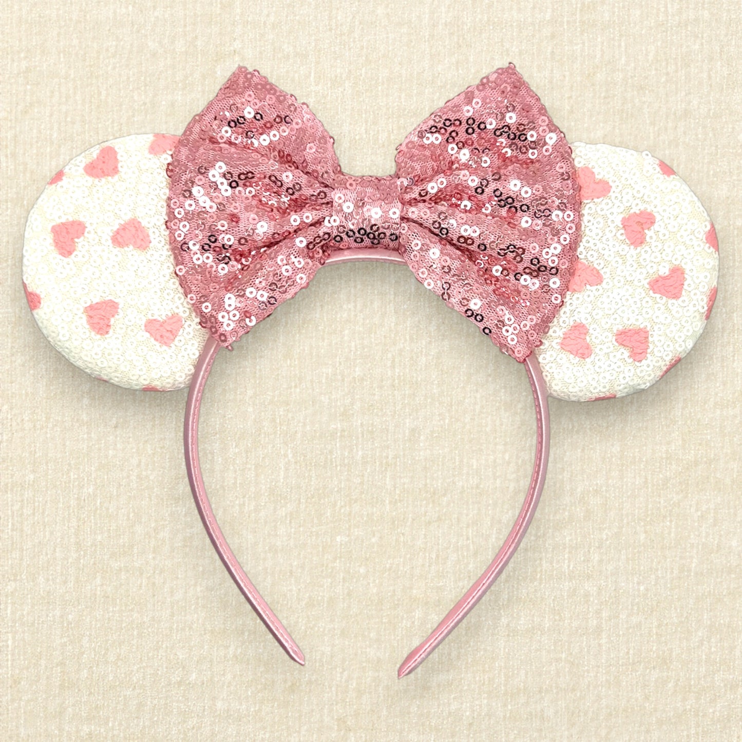White sequin mouse ears with small pink hearts and rose gold sequin bow