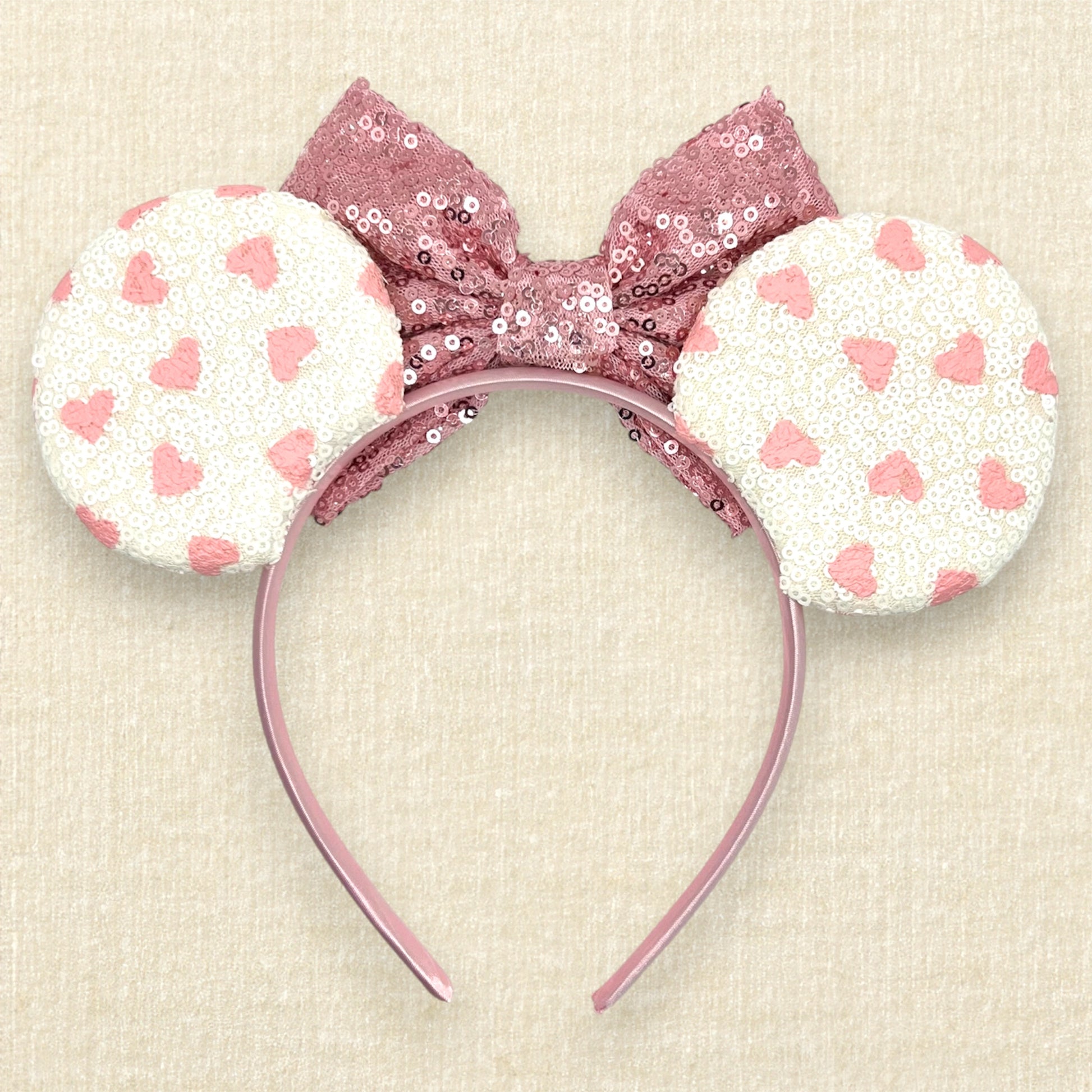 White sequin mouse ears with small pink hearts and rose gold sequin bow (back view)