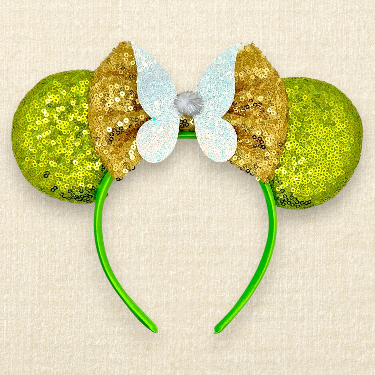 Light green sequin mouse ears headband with gold bow, glitter fairy wings, and pom-pom centerpiece