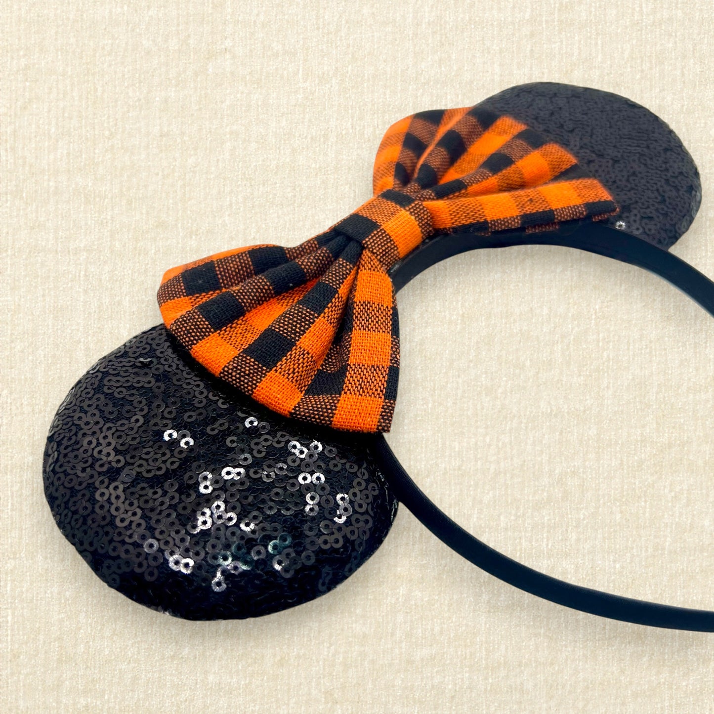 Fall-themed mouse ears with black sequin mouse ears and orange and black buffalo plaid bow