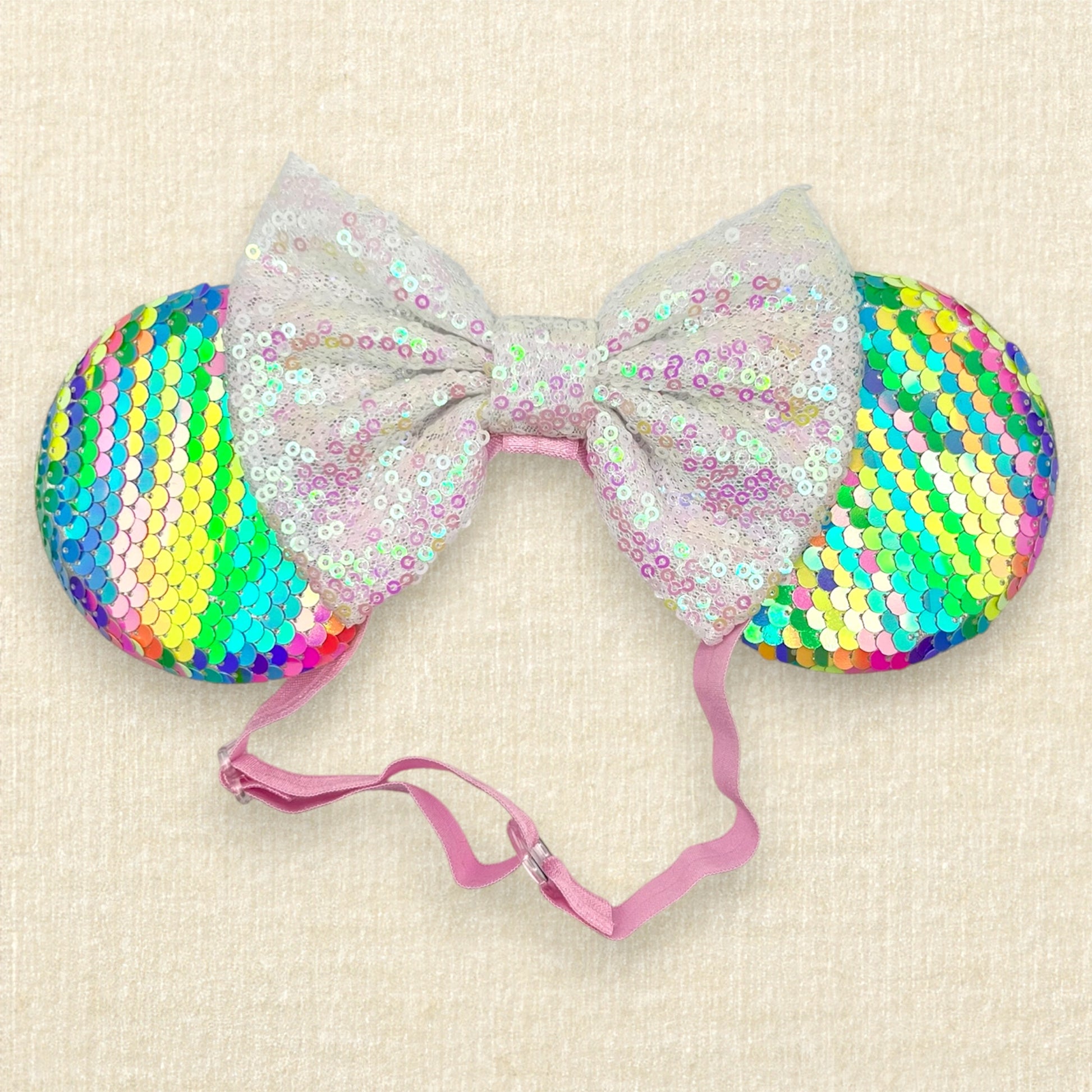 Colorful sequin mouse ears with white sequin bow on an elastic headband