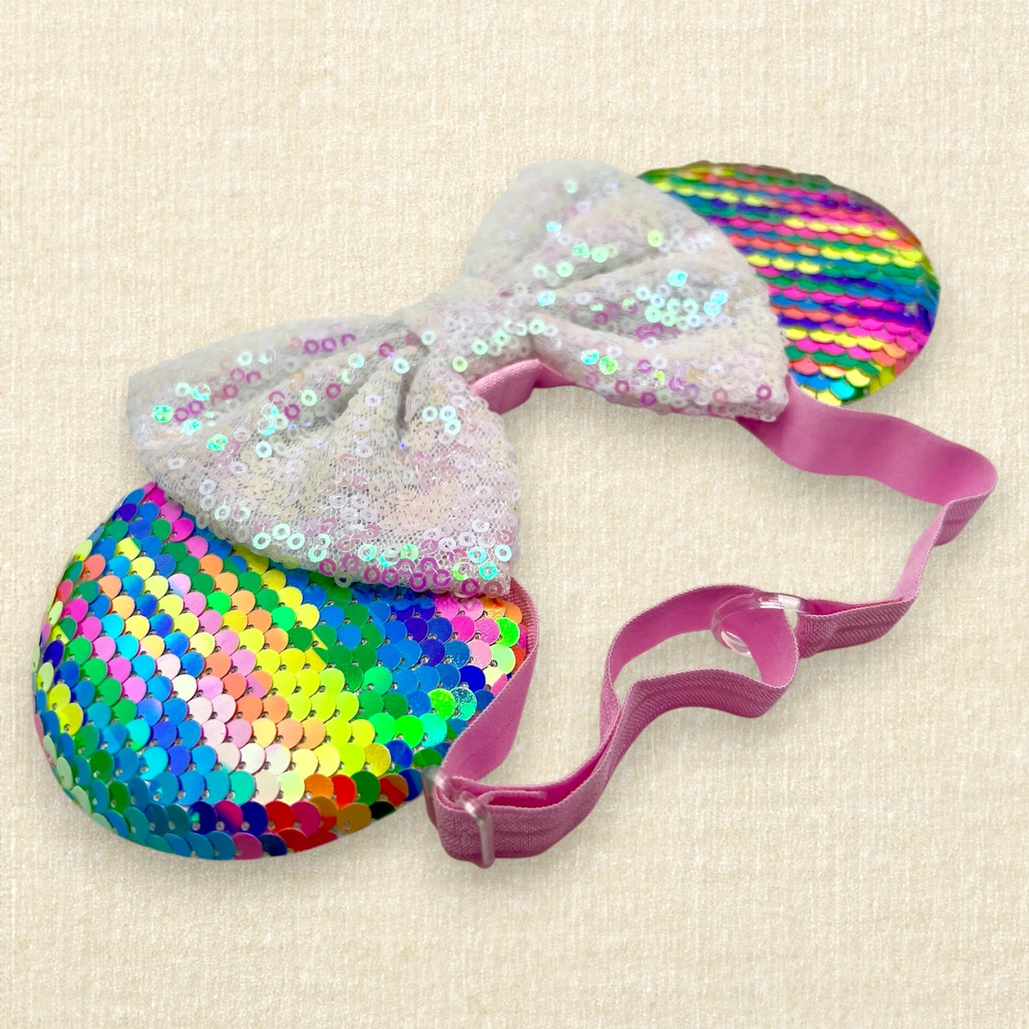 Colorful sequin mouse ears with white sequin bow on an elastic headband