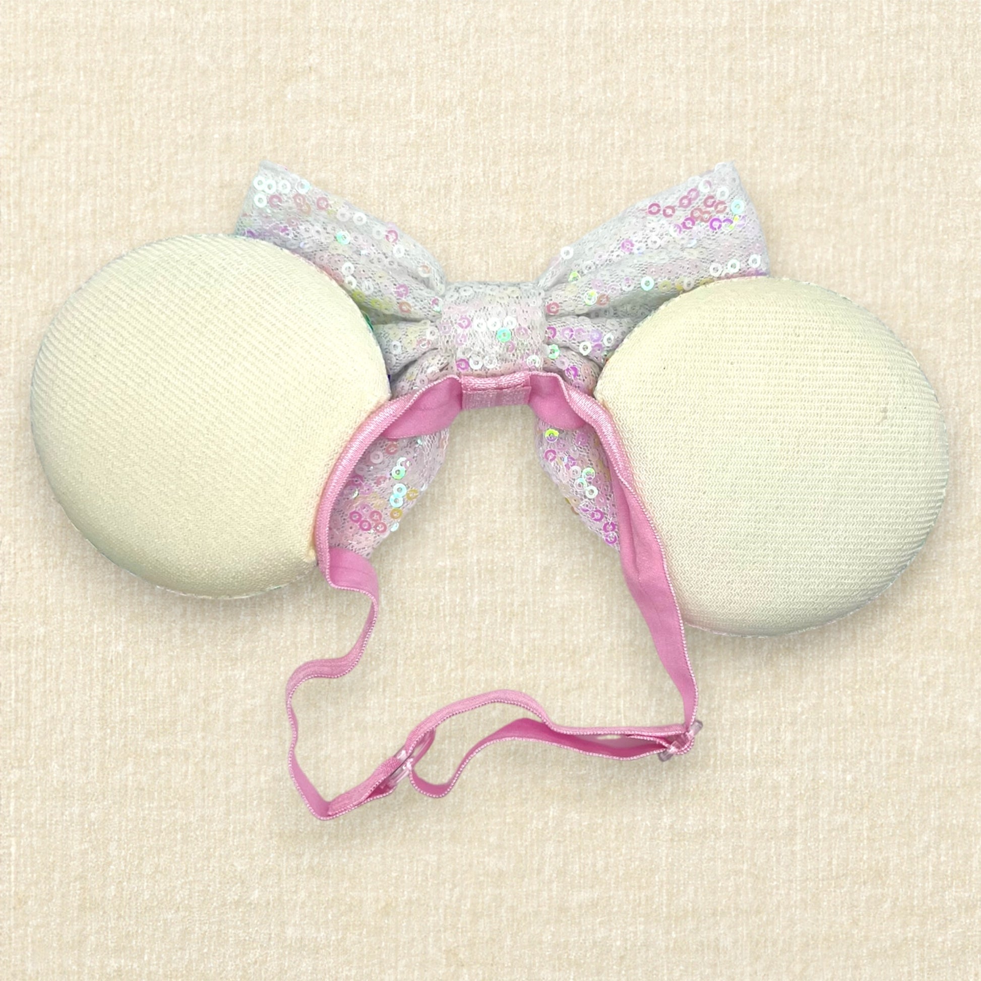 Colorful sequin mouse ears with white sequin bow on an elastic headband (back view)