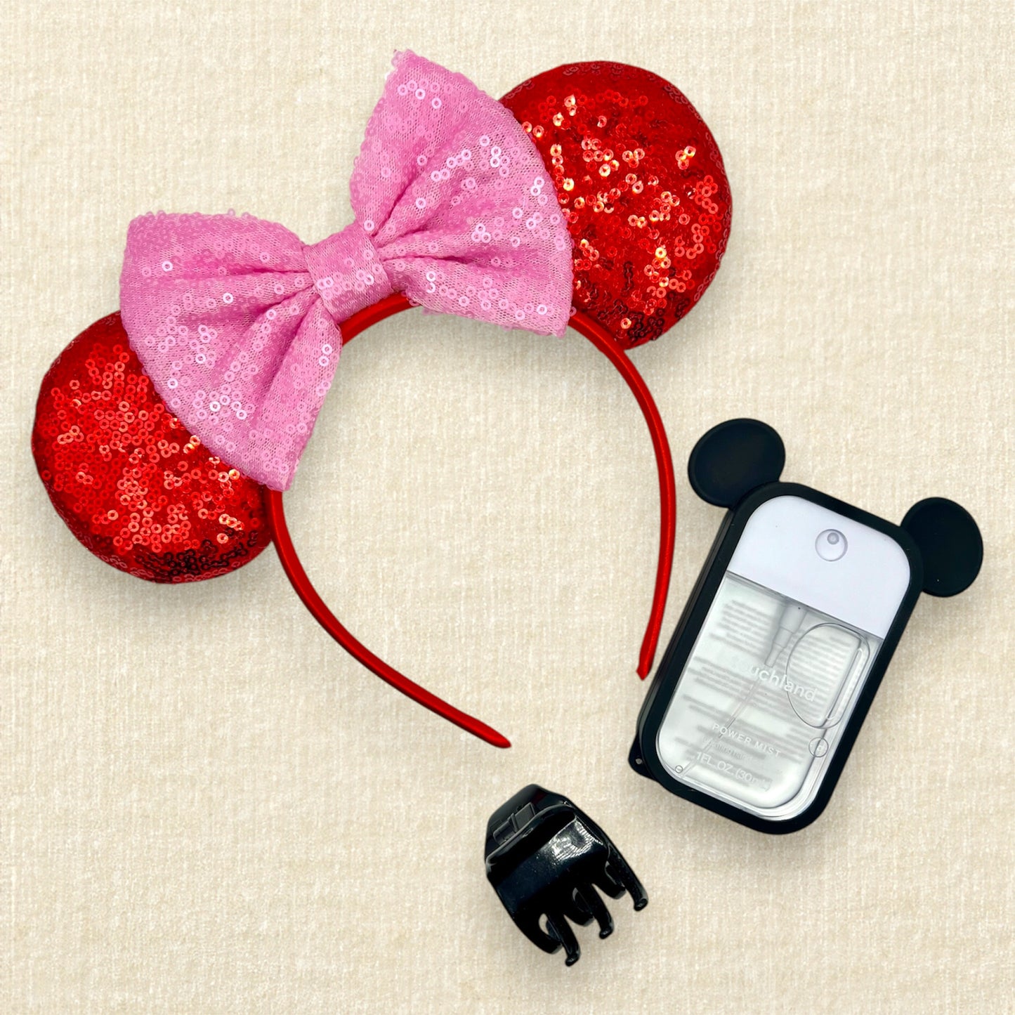 Red sequin mouse ears with a pink sequin bow; spray hand sanitizer with black mouse ears case; black claw clip