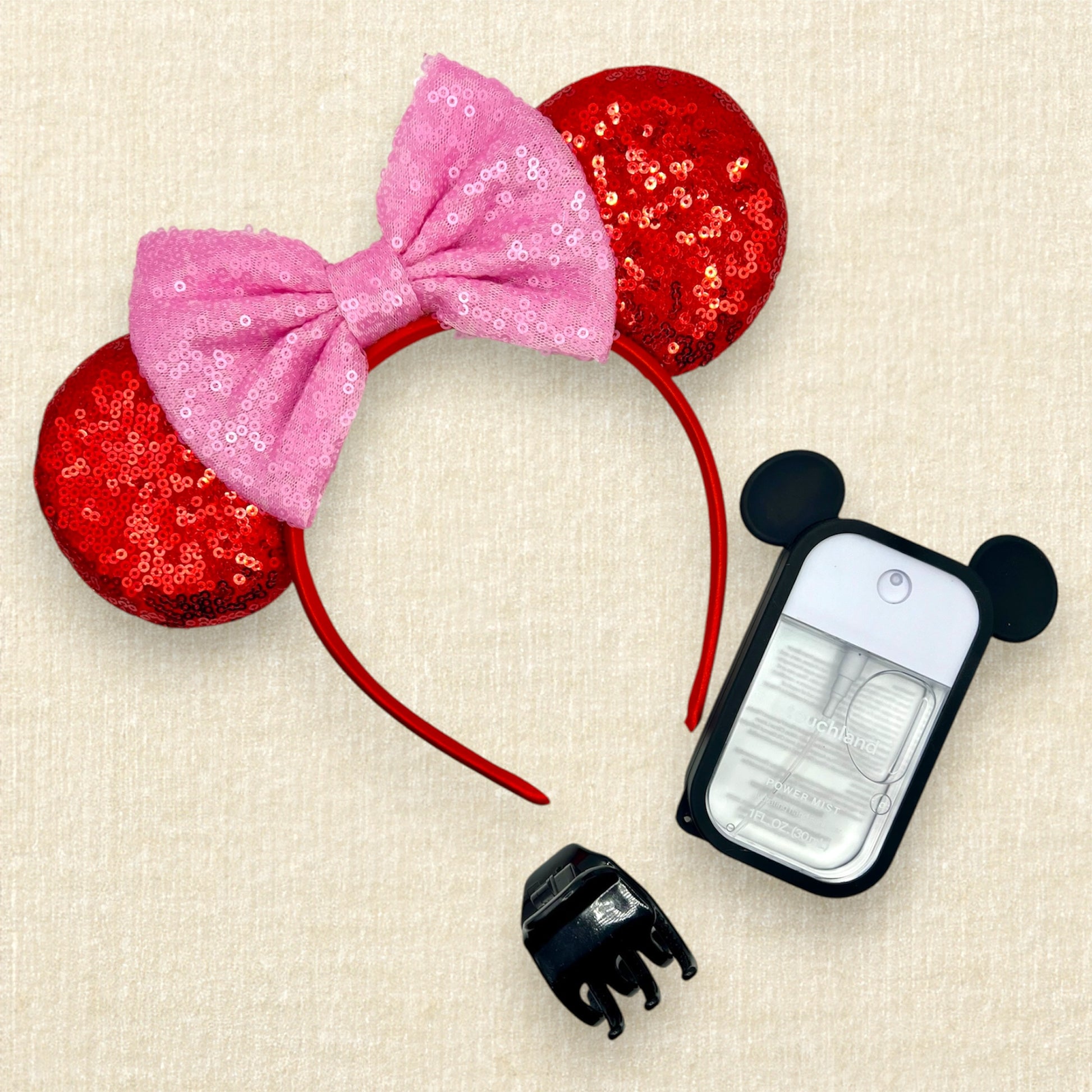 Red sequin mouse ears with a pink sequin bow; spray hand sanitizer with black mouse ears case; black claw clip