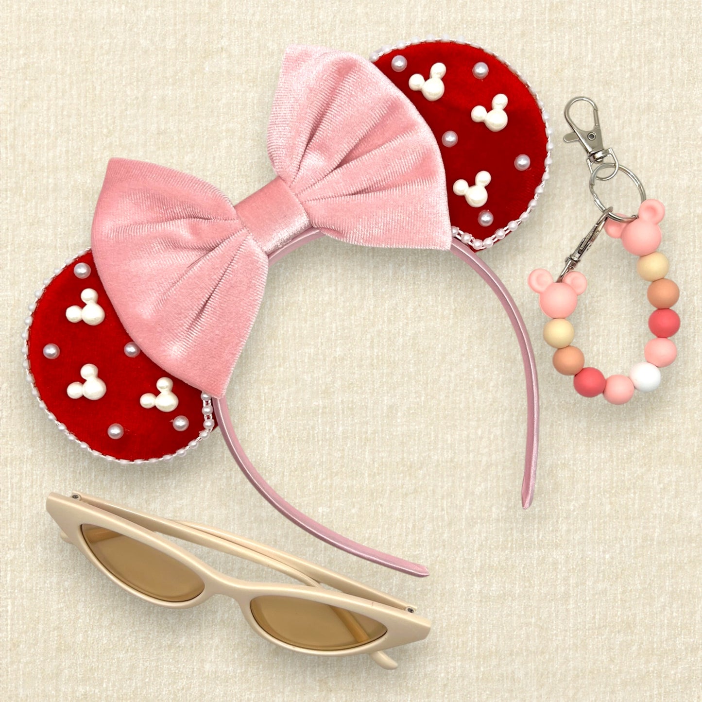 Red velvet mouse ears with mouse and round pearls and pearl trim, with pink velvet bow; cream cat-eye sunglasses; pink beaded mouse ears holder clip