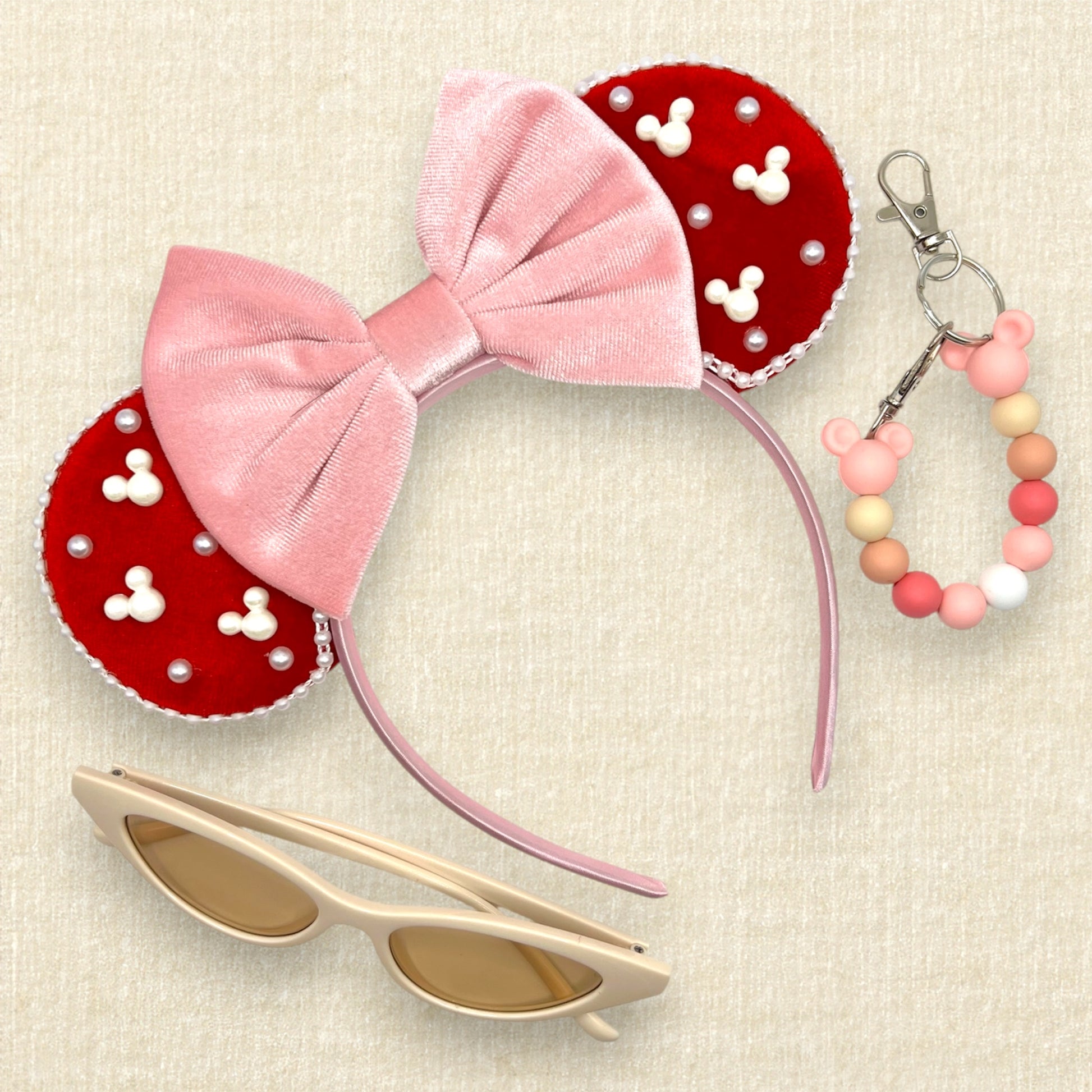 Red velvet mouse ears with mouse and round pearls and pearl trim, with pink velvet bow; cream cat-eye sunglasses; pink beaded mouse ears holder clip