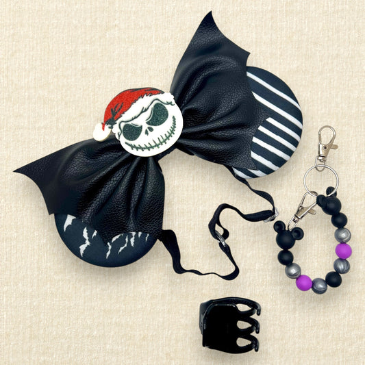 Halloween-themed mouse ears with black and white fabric ears, black faux leather bat wing bow, and glitter Sandy Claws centerpiece on an elastic headband; black claw clip; purple, black, and silver beaded mouse ears holder keychain