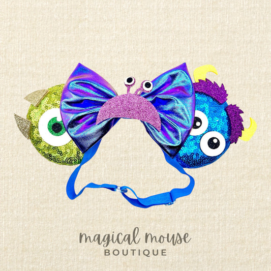 Colorful monster-themed elastic mouse ears headband on a beige background with branding 'Magical Mouse Boutique'