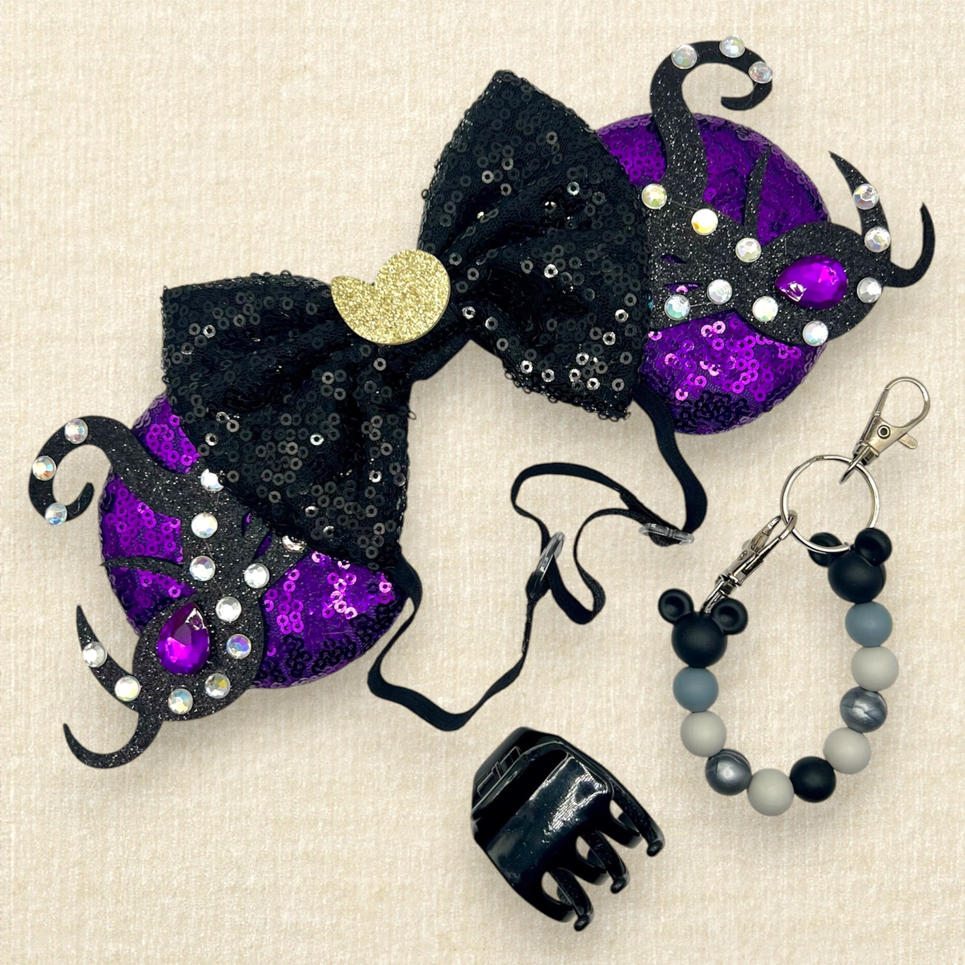 Purple sequin mouse ears with glitter tentacles, rhinestones, and black sequin bow with glitter seashell on an elastic headband; black claw clip; black and silver beaded mouse ears holder clip