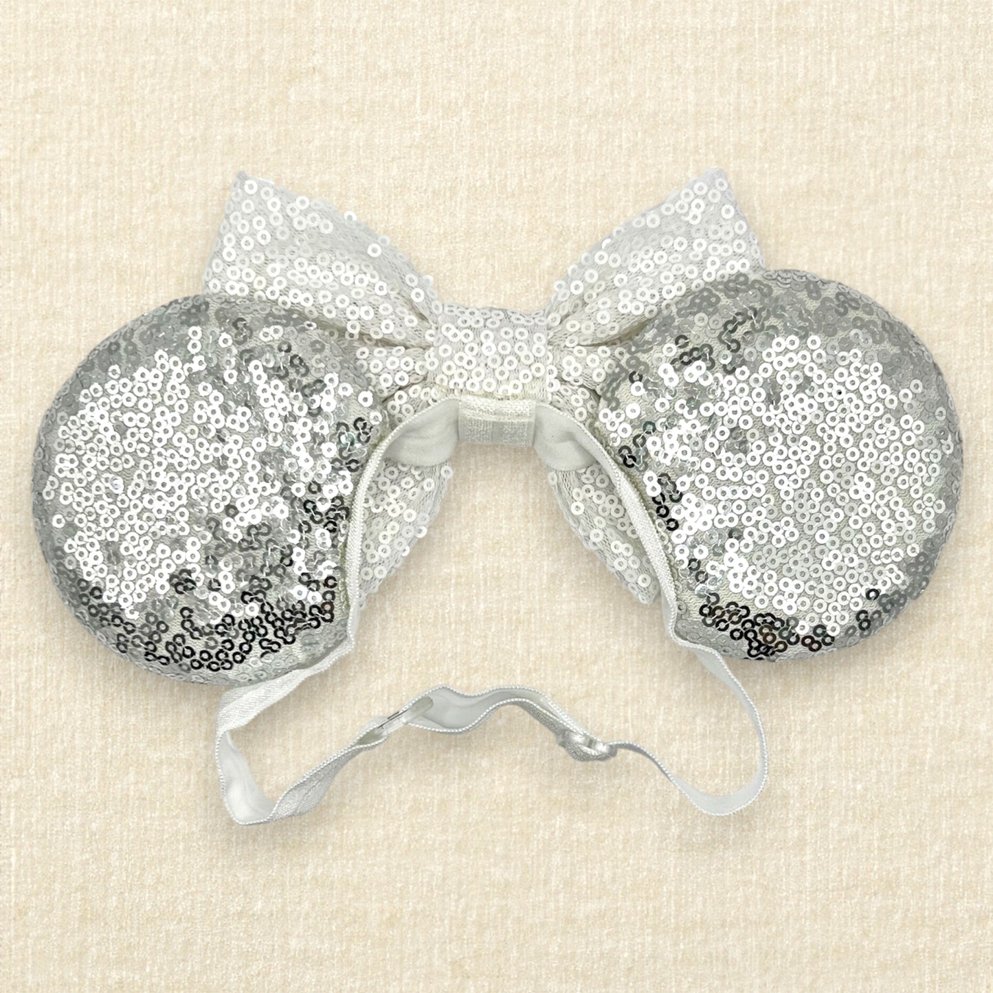 Silver mouse ears with white sequin bow on an elastic headband (back view)