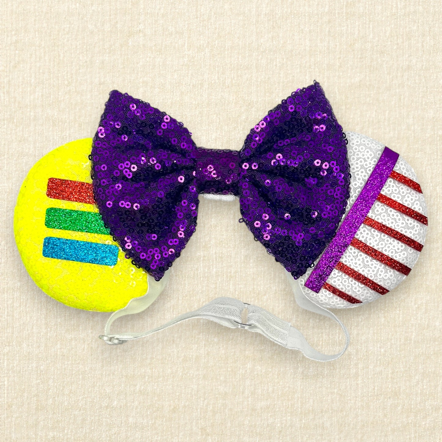 Colorful mouse ears headband with glitter space ranger details and purple sequin bow on an elastic headband