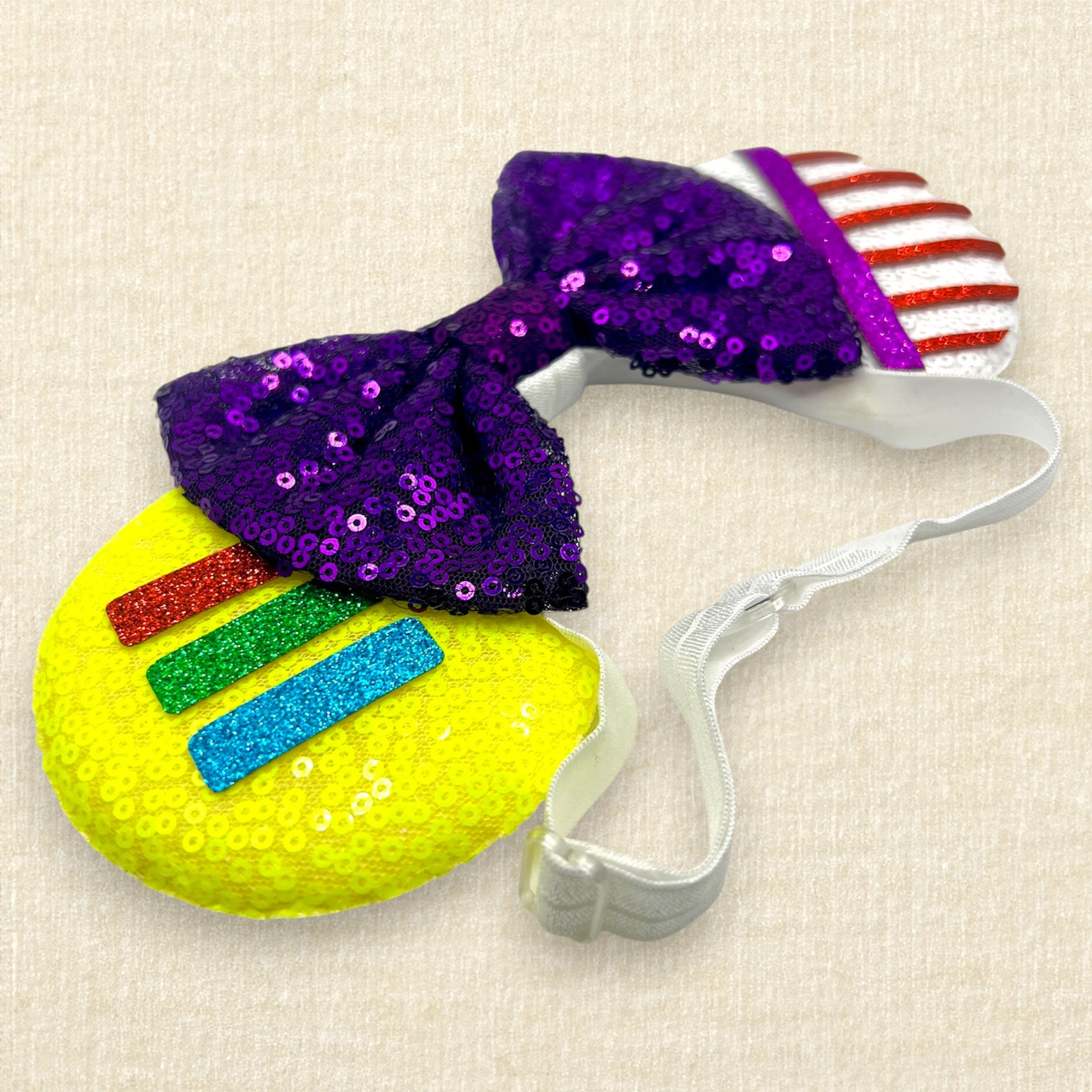 Colorful mouse ears headband with glitter space ranger details and purple sequin bow on an elastic headband