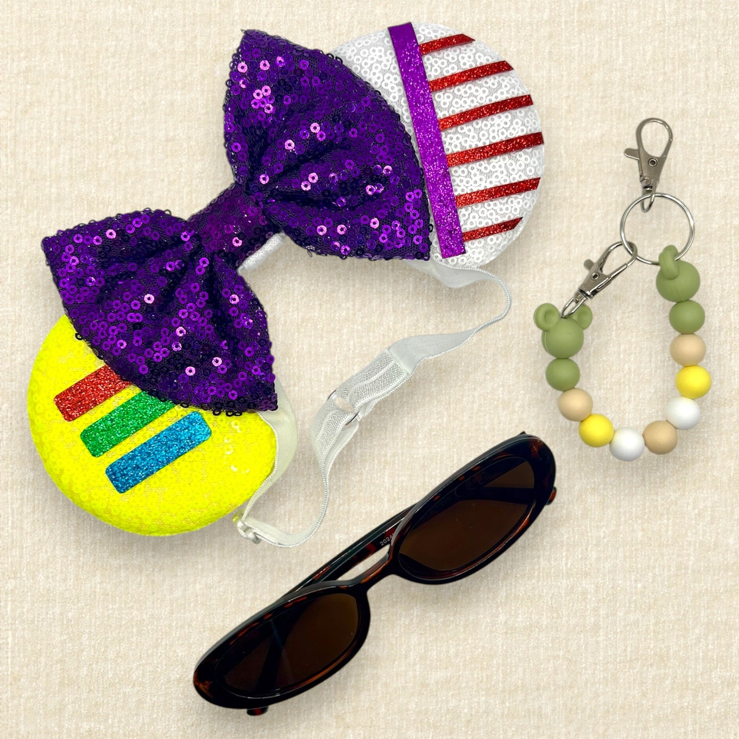 Colorful mouse ears headband with glitter space ranger details and purple sequin bow on an elastic headband; sunglasses; green beaded mouse ears holder clip