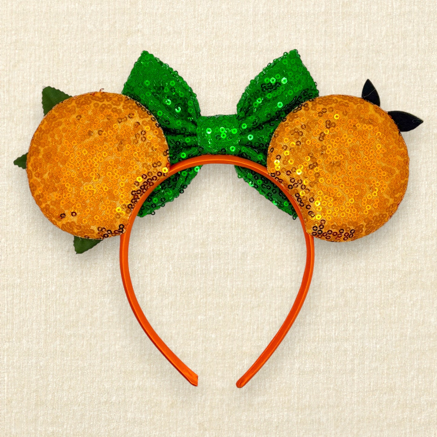 Orange sequin mouse ears with glitter bird details, white fabric daisies, and green sequin bow (back view)