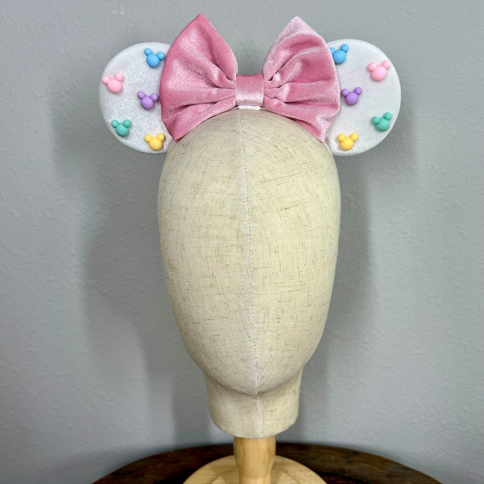 White mouse ears with pastel pink bow and pastel mouse shaped pearls on a mannequin