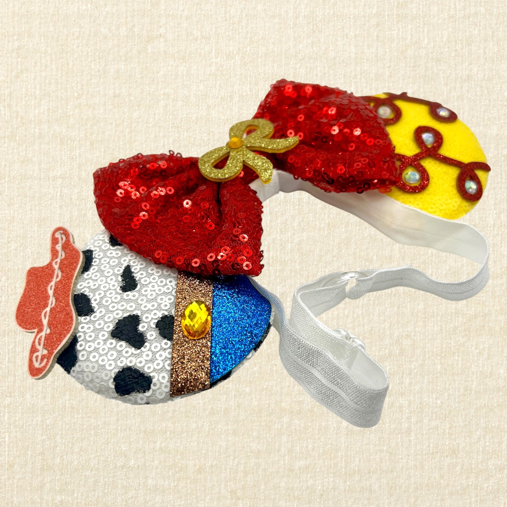 Colorful cowboy-themed mouse ears headband with glitter details, rhinestones, and red sequin bow on an elastic headband